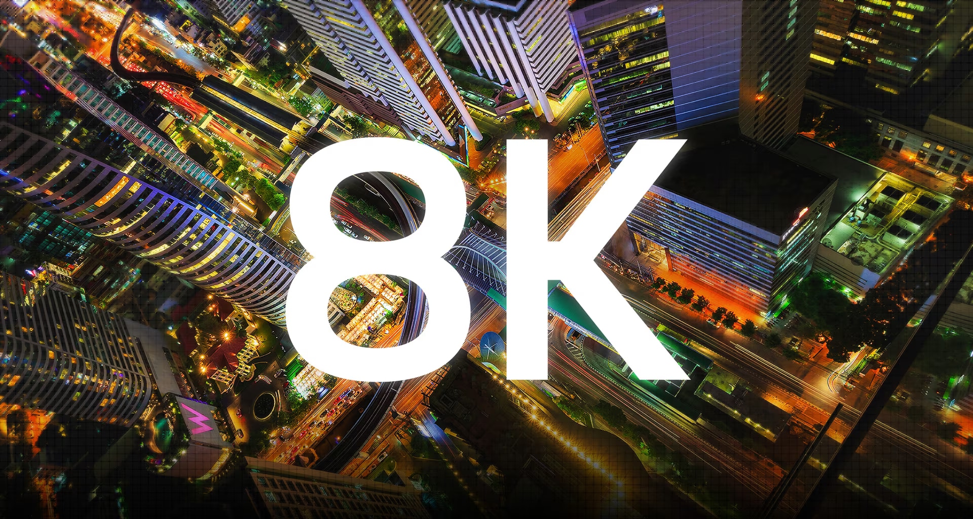 Numerous pixels come together to make a detailed birds-eye night view of a city of a city and then the word 8K appears