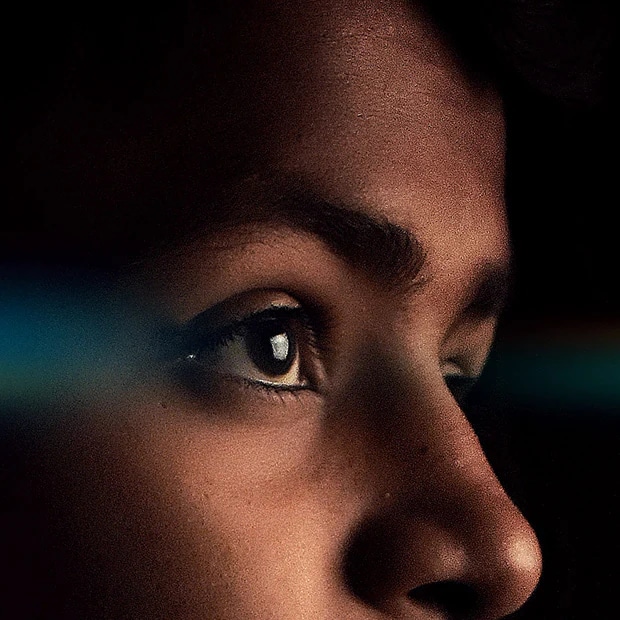 A side closeup view of a child looking towards a television that is not in the frame