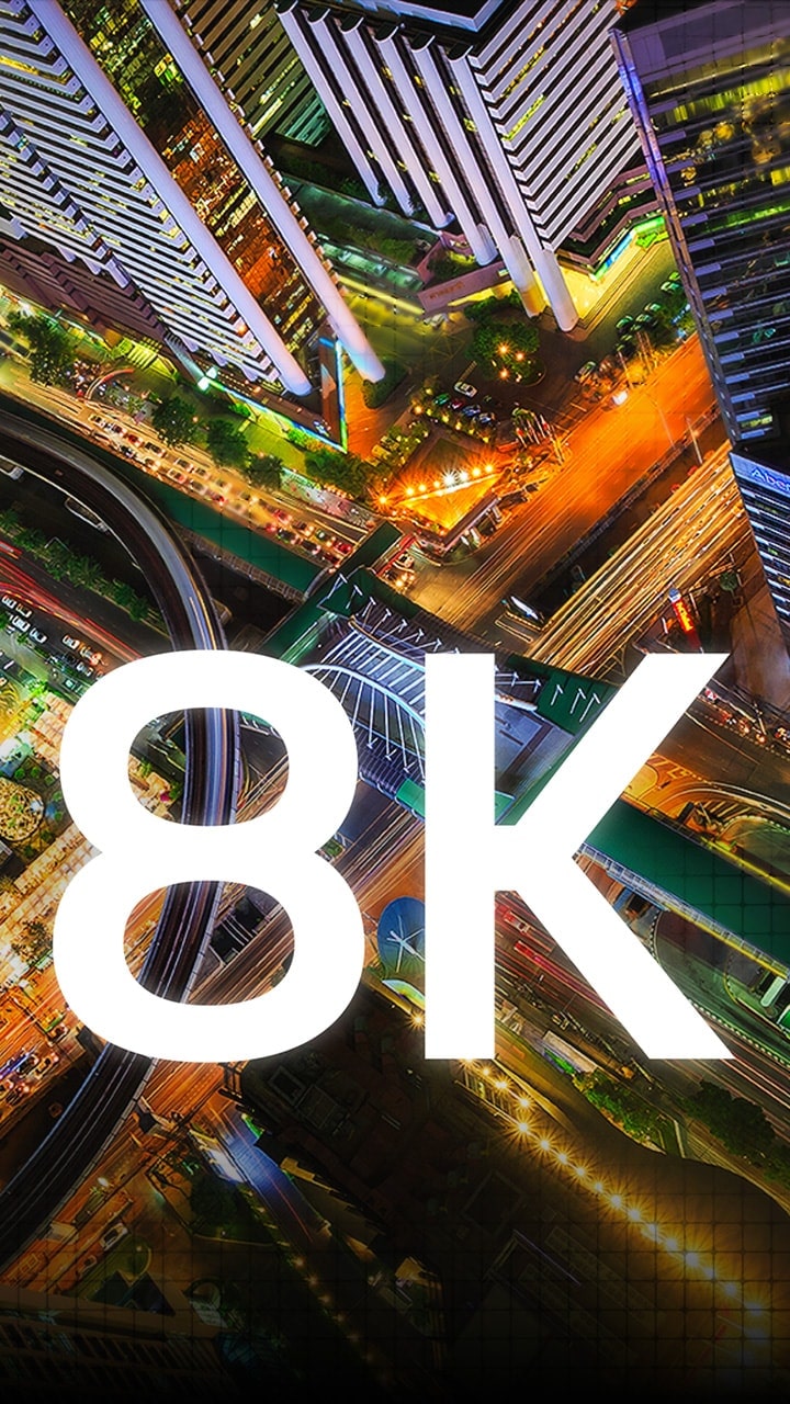 Numerous pixels come together to make a detailed birds-eye night view of a city of a city and then the word 8K appears