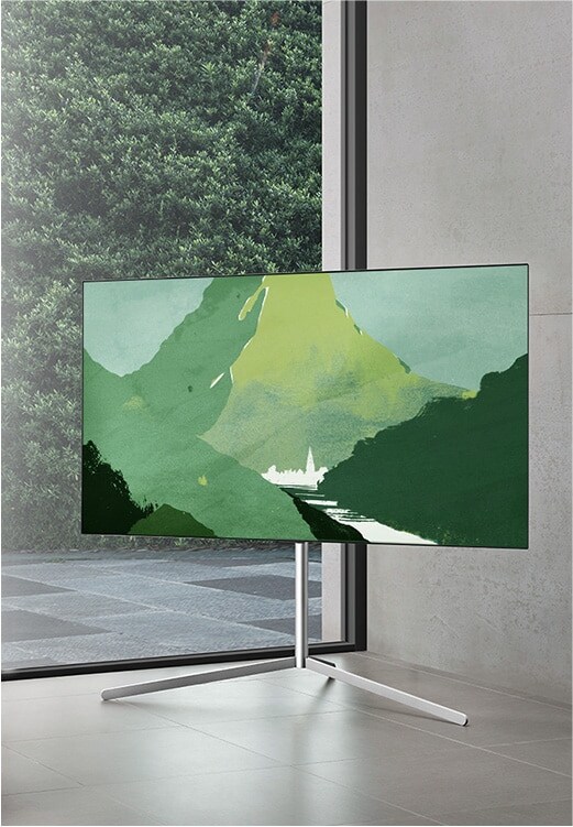 LG OLED televízió egy modern, szürke helyiségben egy medencére néző ablak előtt. LG OLED egy természetes nappaliban, ahol szabadon láthatók a téglák, a fa részletei és a növények.