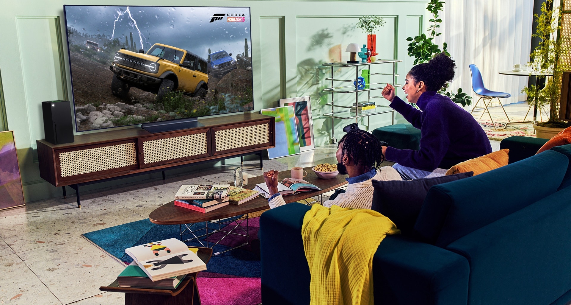 Uma pessoa joga um jogo de corrida com um controle de XBOX Series X|S em uma televisão LG OLED