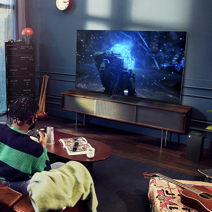Pessoas jogam com um controle na TV LG OLED