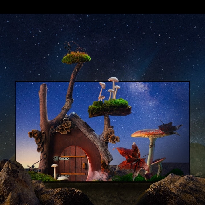 Uma casinha de aparência fantástica, com árvores, cogumelos e grandes rochas, está sob o céu noturno estrelado.