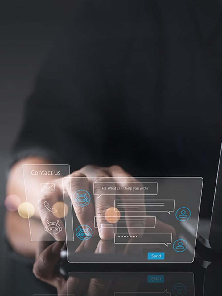 Dos ventanas holográficas virtuales de chat y contacto flotan junto a una laptop, mientras unas manos se posicionan detrás de ellas.