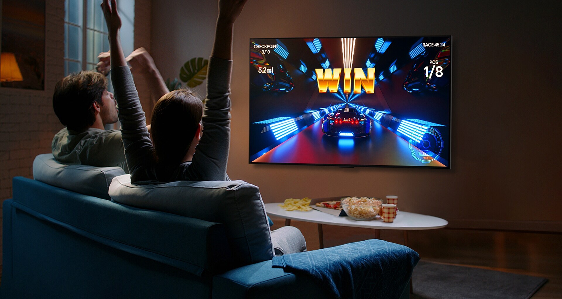 Osoby grają w grę za pomocą kontrolera na telewizorze LG OLED