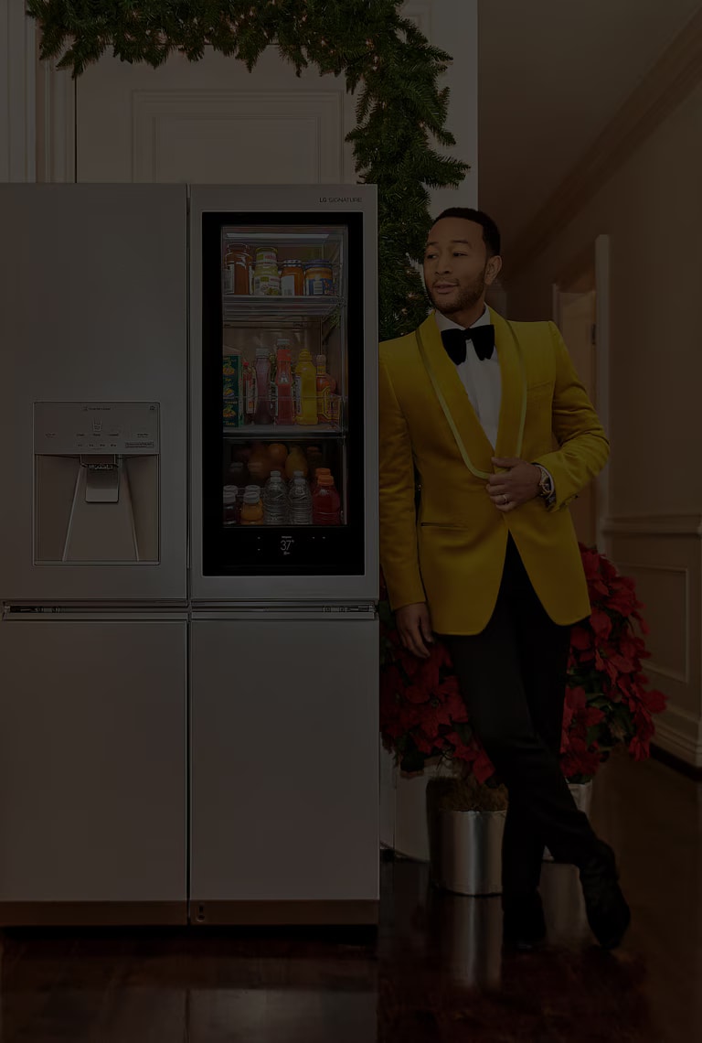 Sångaren John Legend lutad mot ett LG SIGNATURE-kylskåp.