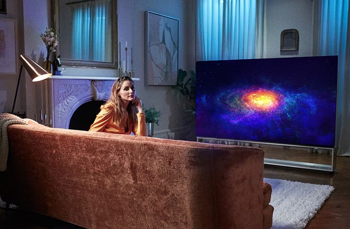 Olivia Palermo 躺在沙發上休息,一邊欣賞 LG SIGNATURE OLED 8K 電視播放的節目