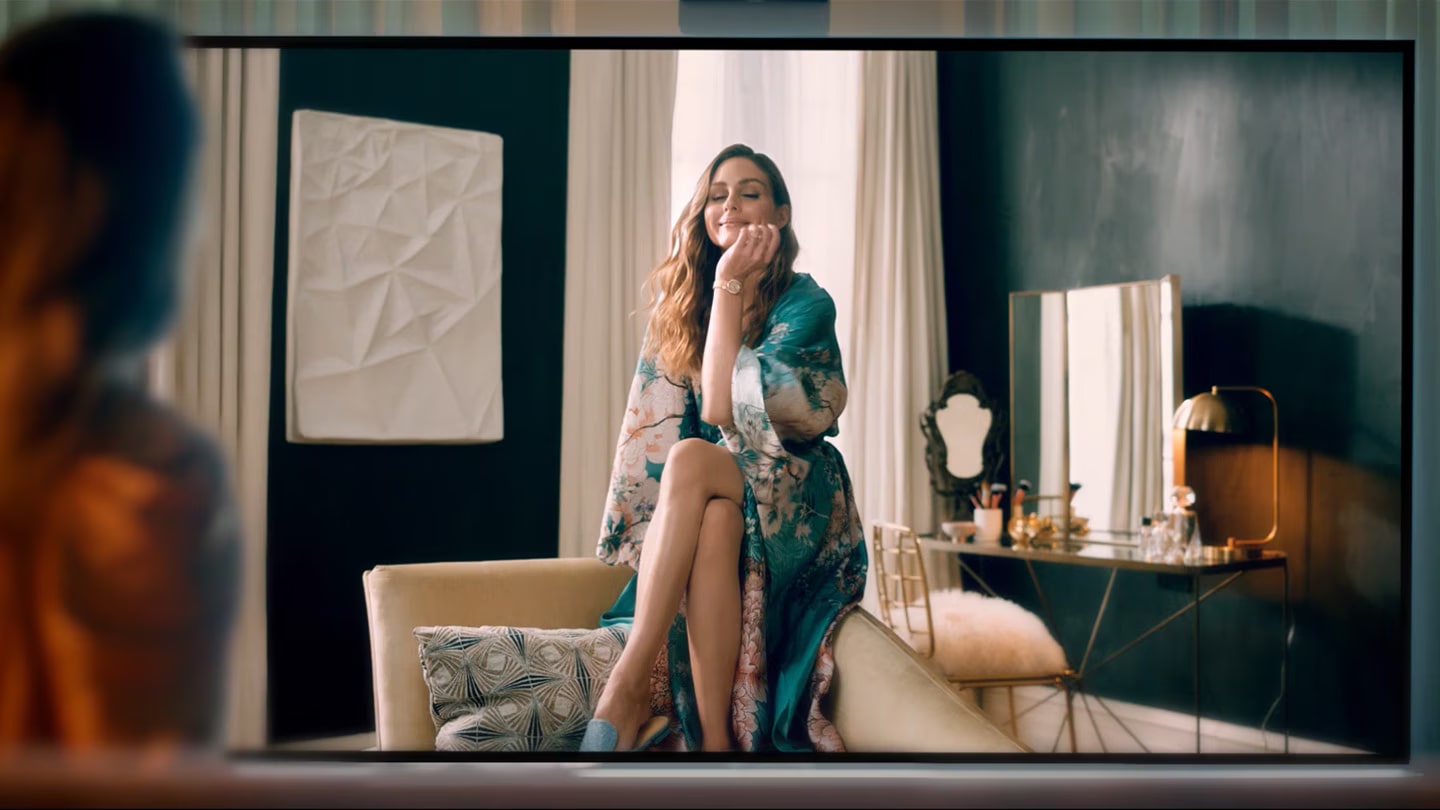 Olivia Palermo 注視著 LG SIGNATURE OLED 8K 電視中的自己,被深邃無比的黑色、鮮艷的色彩和栩栩如生的畫質吸引住了