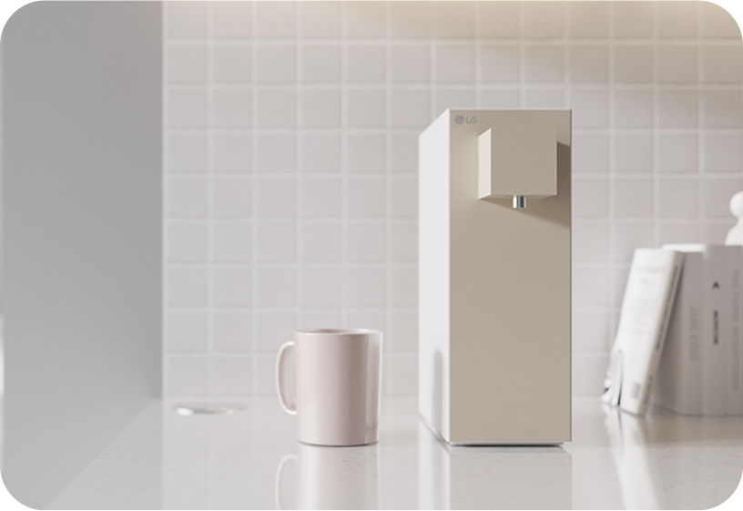LG water purifier with minimalist beige design placed on a modern kitchen counter beside a mug for clean drinking water