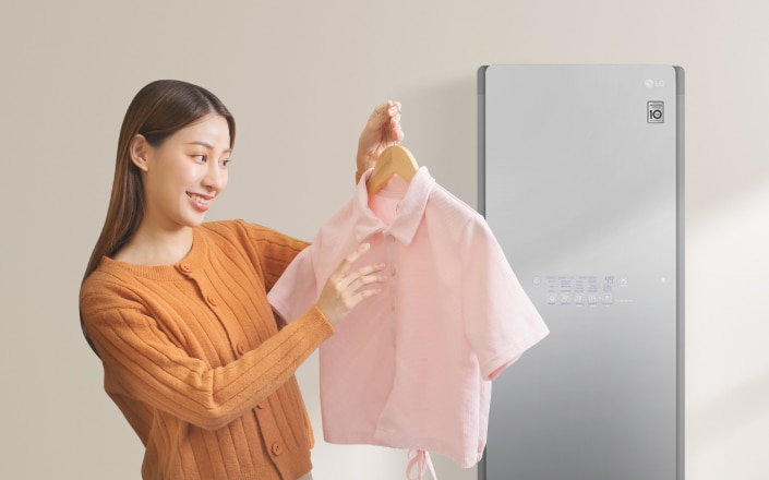 LG月租美好計畫輕鬆擁有高質感家電，一名女子從Styler蒸氣電子衣櫥內拿出藍色毛衣，享受LG家電為衣物帶來潔淨的美好便利生活。