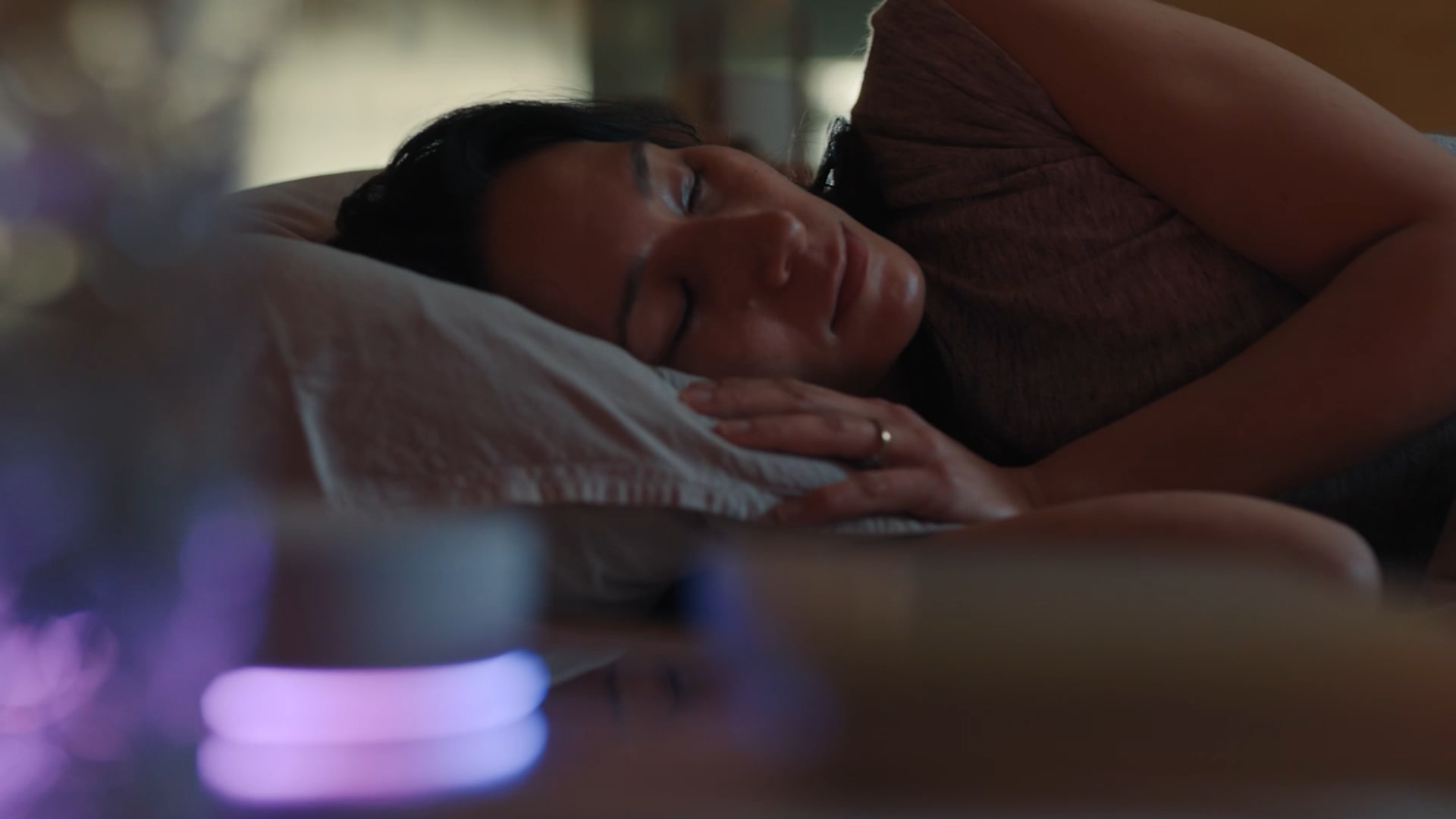 A woman lies on her side, sleeping in bed, as the glowing LG AI device greets her with 'Good morning.' A dog walks past the LG StanbyMe screen displaying the words 'Good morning.' A woman slides open a frosted glass door and enters. Inside the laundry room, a boy is placing laundry into the LG washing machine. A man and a woman lie intertwined on the living room sofa. A soccer match is playing on the TV screen. A woman and a man are hugging each other joyfully while having a conversation. The lights and TV are on, then they automatically turn off one by one. The LG robot vacuum starts moving across the floor.