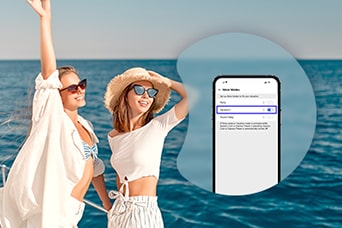 Bild von zwei Frauen am Strand mit einem Smartphone auf dem Bildschirm, das den LG MoodUP® Kühlschrank steuert.