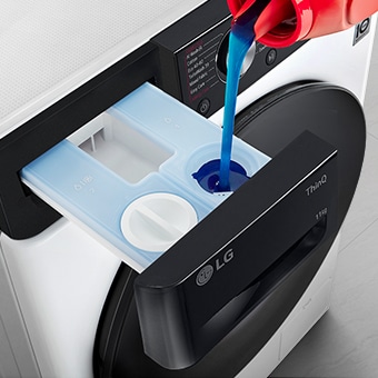 Detergent is pouring into the washing machine's detergent container.	