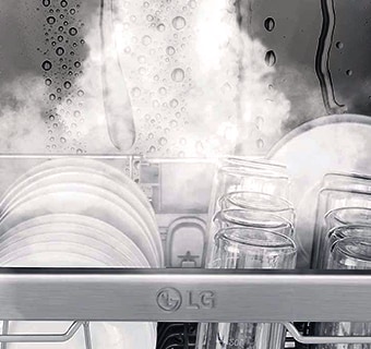 Detailní záběr nádobí a sklenic mytých párou v myčce.
