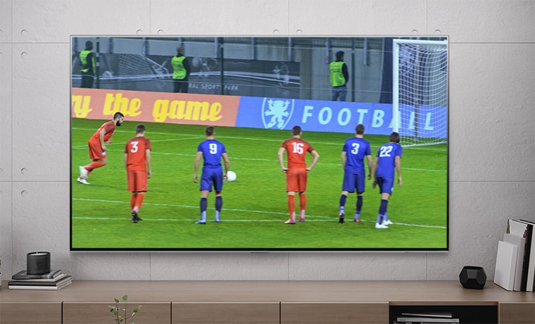 Televizní obrazovka zobrazující fotbalistu střílejícího penaltu (přehrát video)