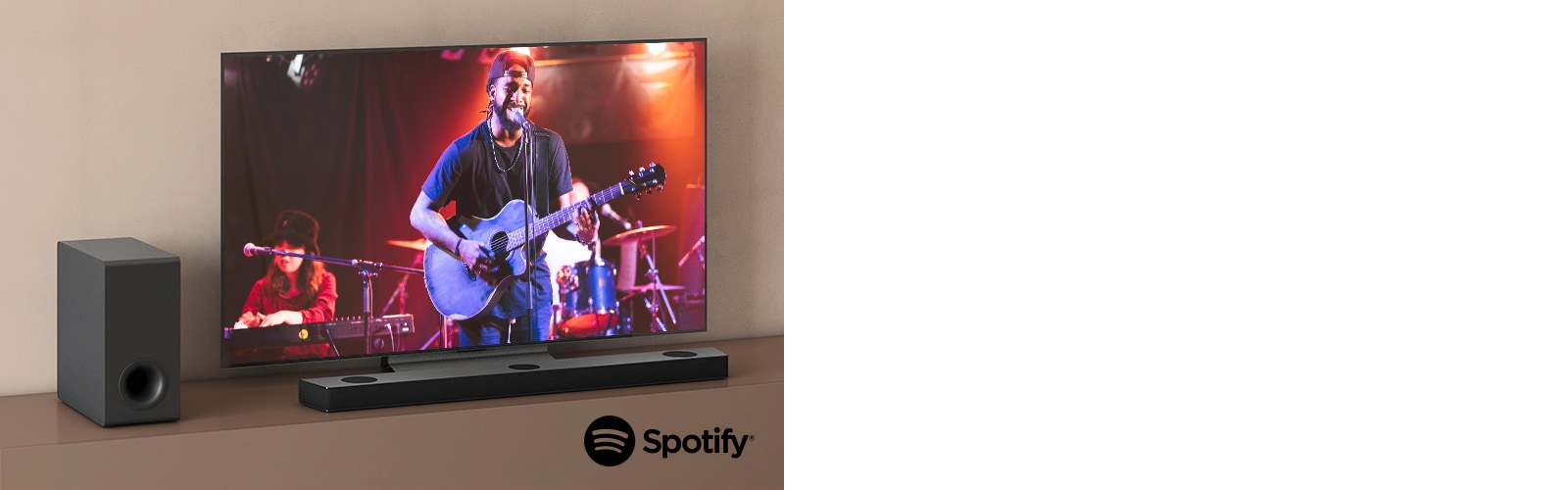 Televizor LG zobrazuje koncert a Sound Bar LG je umístěn pod televizorem. Vlevo na hnědé polici je subwoofer.