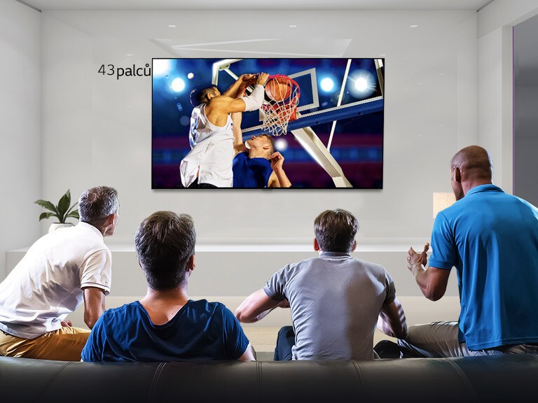 Pohled zezadu na TV připevněný na stěnu, na kterém se odehrává basketbalový zápas, který sledují čtyři muži. Posun zleva doprava ukazuje rozdíl ve velikosti 43palcové a 86palcové obrazovky.