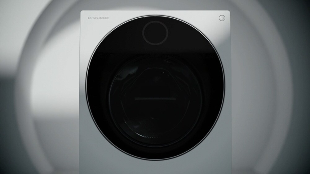 Zobrazuje pohled zepředu na pračku se sušičkou LG Signature. Na obrázku je tlačítko pro přehrání videa.