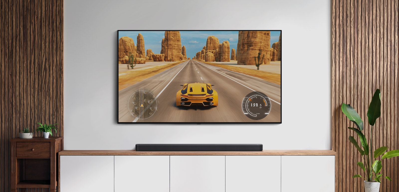 Obývací pokoj s TV a soundbarem. Na TV obrazovce je závodní auto. (přehrát video)