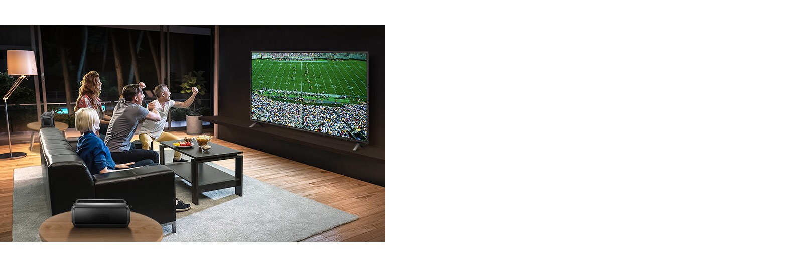 Lidé sledující sportovní zápas na televizoru v obývacím pokoji se zadními reproduktory Bluetooth.
