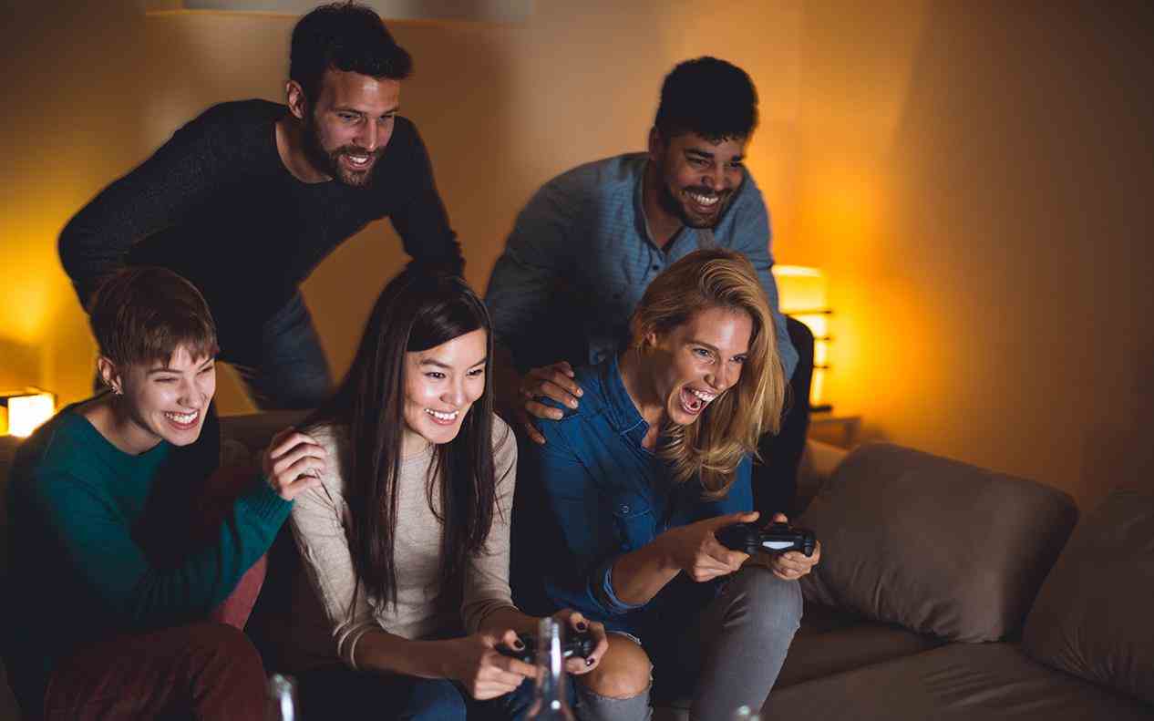 A group of friends playing a video game on a lg super uhd 4k tv