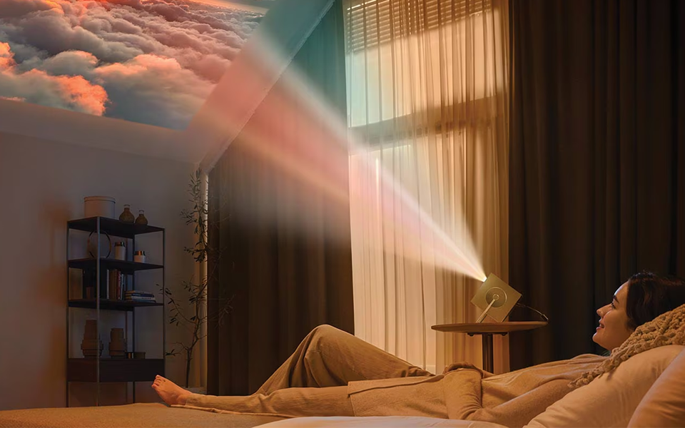 A woman lying down and watching a video projected on an LG 4K projector