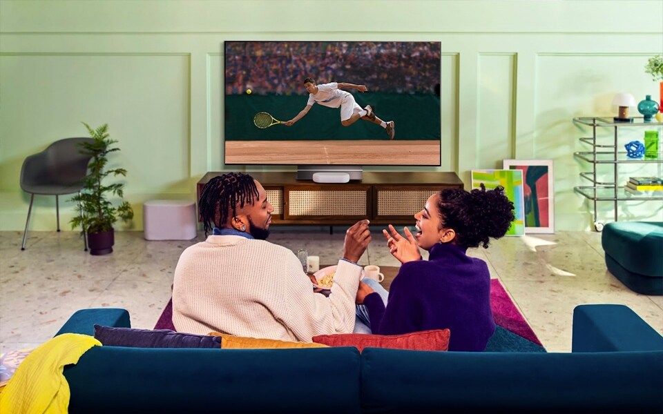 A couple watches tennis on their LG OLED evo TV