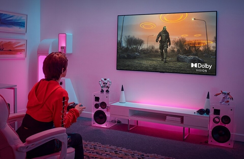 Gamer spielt in einem stilvollen Raum auf einer Gaming-Konsole über einen LG OLED-Fernseher.