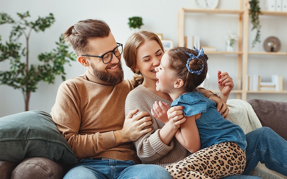 An image of a family sitting on their living room sofa, enjoying the smart good life with their LG products.