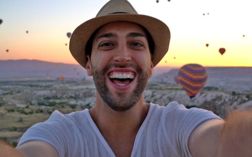 A man smiling into the LG Velvet camera with hot air balloons in the background
