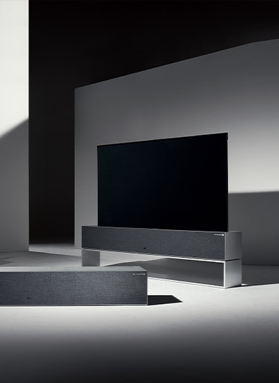 Drei LG SIGNATURE OLED R Fernseher in einem schwach beleuchteten Raum. Jeder TV befindet sich in einem anderen Modus: der Fernseher in der Mitte ist in der Zero View, der linke Fernseher in der Line View und der rechte in der Full View.