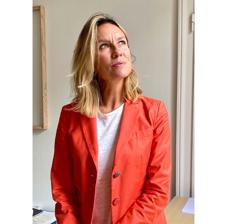 Nahaufnahme von Francesca Molteni, einer Frau mit heller Haut mit schulterlangem blonden Haar. Sie trägt ein weißes T-Shirt und eine rote Jacke.