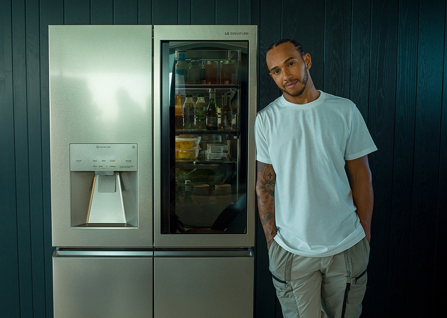 Lewis Hamilton lehnt sich an den LG SIGNATURE InstaView Door-in-Door™-Kühlschrank an.