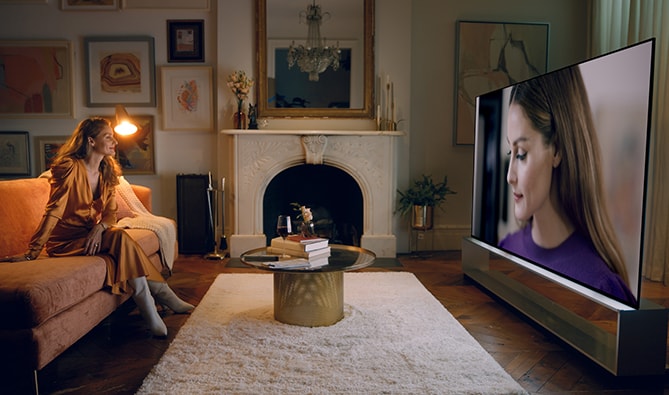 Olivia Palermo sieht sich selbst auf dem LG SIGNATURE OLED 8K-Fernseher im Wohnzimmer.