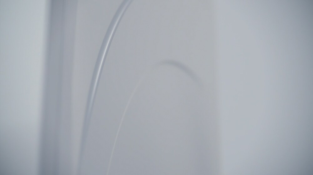 LG SIGNATURE Vaskemaskinen er placeret i midten af billedet med fokus på den hvide, emaljebelagte beklædning.