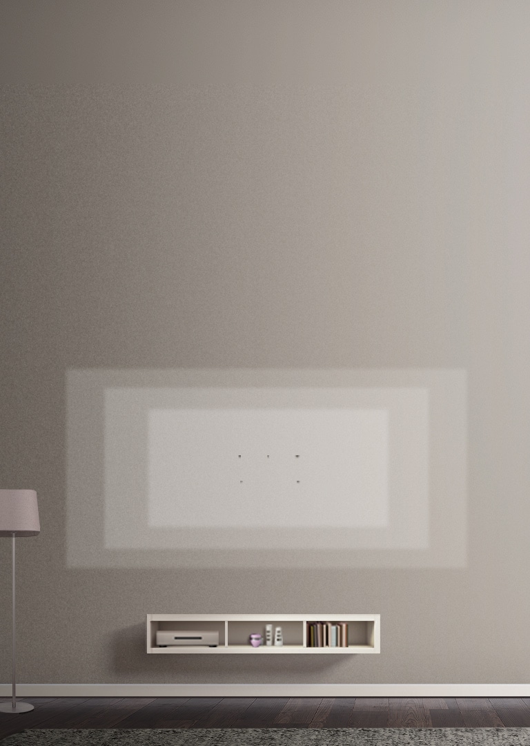 Des repères désignent les différents formats de téléviseurs ultra-larges sur le mur d’un salon décoré avec un support rose, des cadres et une table de téléviseur.