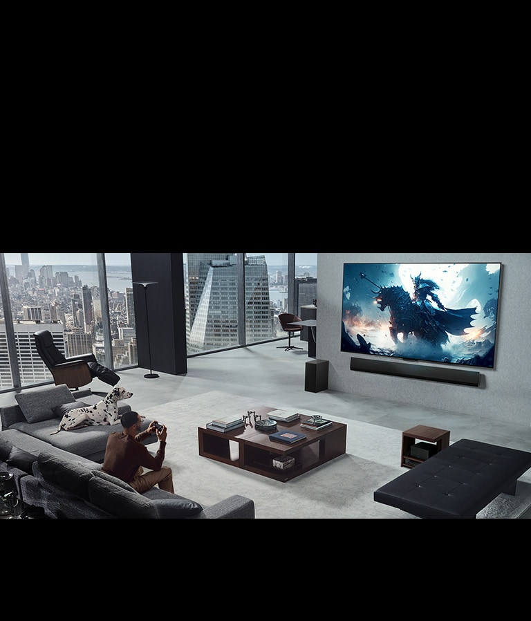 Salon avec une personne jouant à un jeu vidéo sur sa TV LG True Wireless et sa LG Soundbar fixées au mur. Il tient une manette dans sa main, mais la console de jeu n’est pas immédiatement visible. Il n’y a pas non plus de câbles visibles. Le boîtier Zero Connect est rangé, à peine visible sous une table d’appoint.