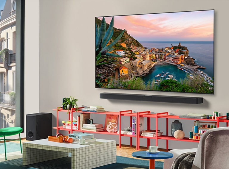 Dans un salon coloré se trouve une LG OLED TV murale avec Soundbar. La perspective est inclinée, montrant le cadre ultra fin de la TV contre le mur. 