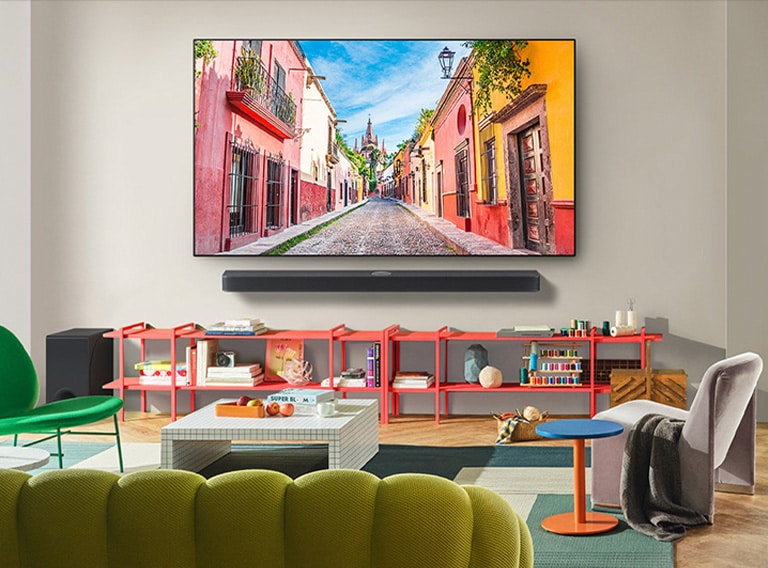 Vue de l’avant de la LG OLED TV murale avec Soundbar dans un salon coloré présentant son design ultra fin et la façon dont elle se fond parfaitement dans l’espace. 