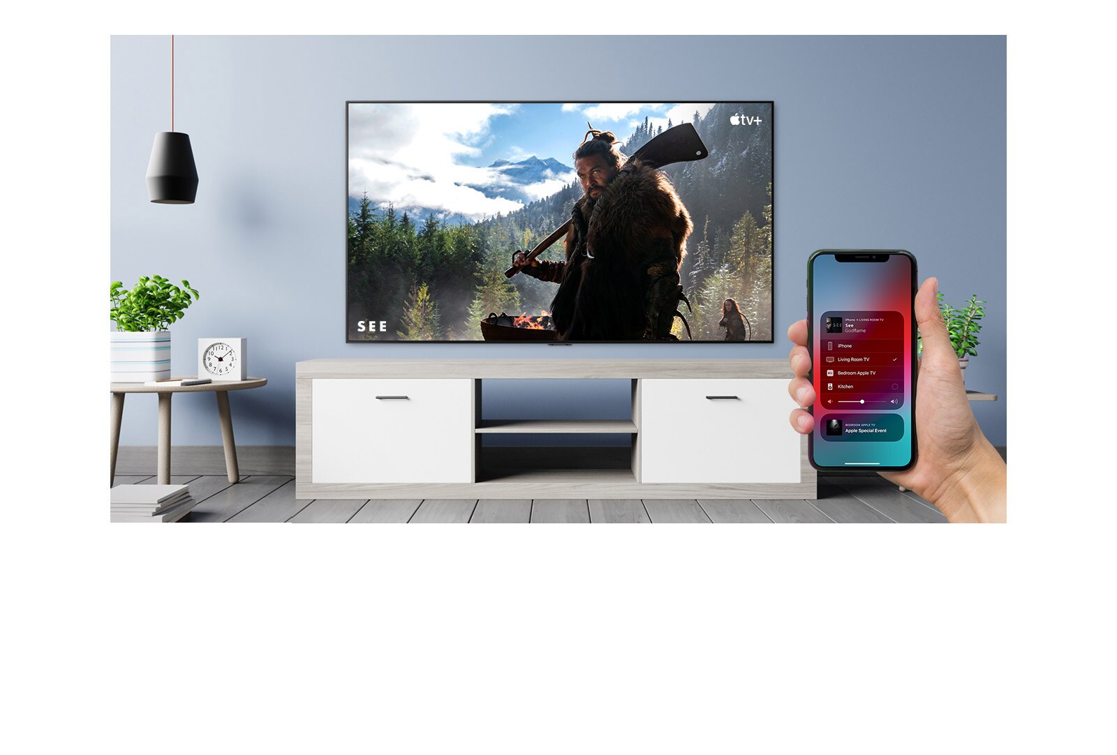 Gros plan d’une main contrôlant le téléviseur avec un iPhone et du téléviseur affichant un contenu Apple TV+