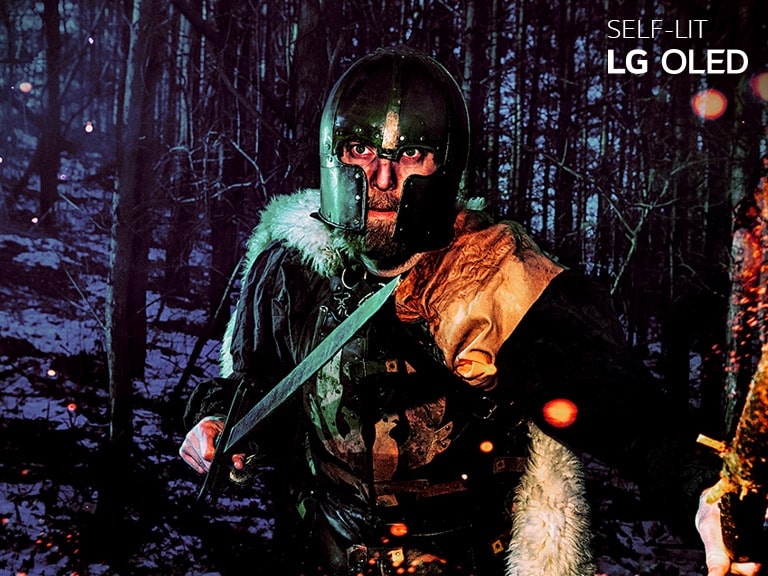 Comparaison par coulissement d’un téléviseur LG LCD/LED et d’un LG OLED sur la reproductibilité des couleurs à partir d’une image d’un homme portant une armure dans un bois en hiver