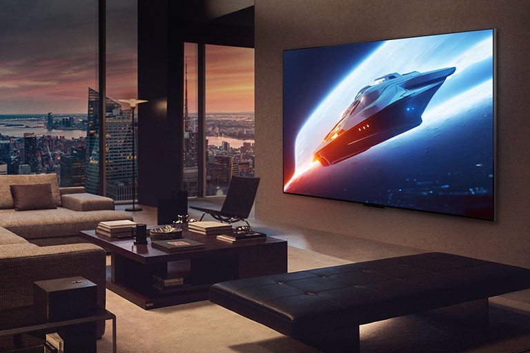 Salon élégant dans un appartement penthouse. Magnifique paysage urbain visible à l’extérieur de la fenêtre. Un homme assis sur le canapé regarde du contenu sur une TV fixée au mur. 