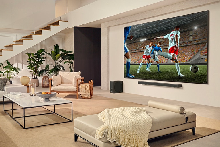 Une famille est rassemblée autour de leur LGTV ultra large et regarde un match de football passionnant sur le très grand écran.