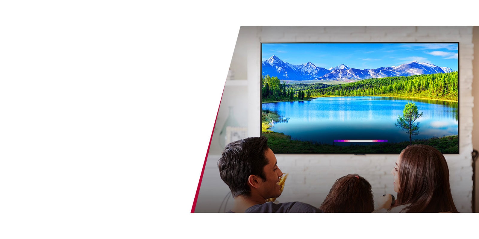 Famille assise sur le canapé et utilisant les fonctions connectées du téléviseur LG