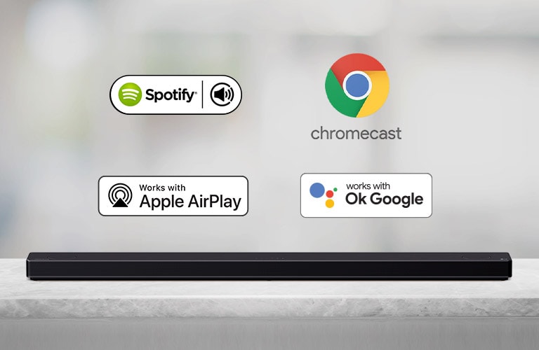 There is a soundbar placed on a gray shelf and there are AI platform logos, in order of Spotify, Alexa, Chromecast, Apple Airplay, and OK Google from left to right.