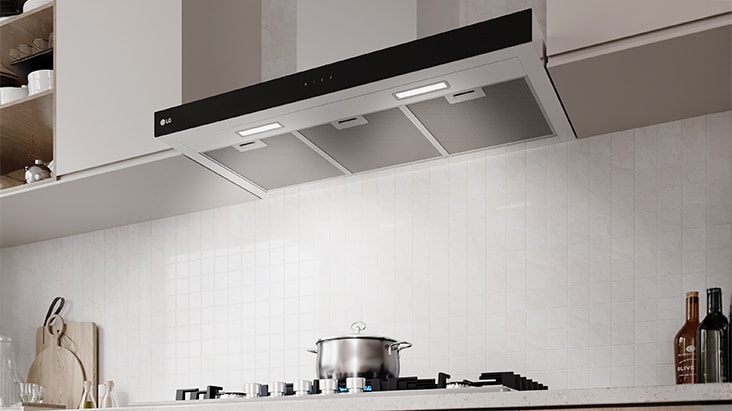 A built-in hood with LED lighting illuminates the gas cooktop and cooking area below.
