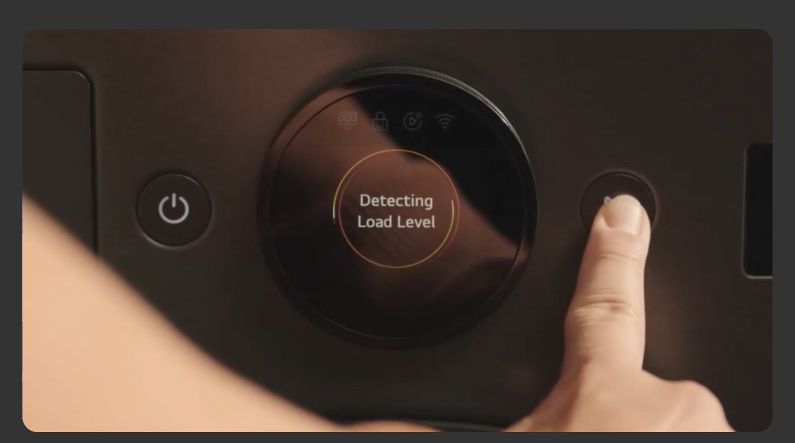 A close-up image of a dryer control panel as a finger presses an operation button on the right.
