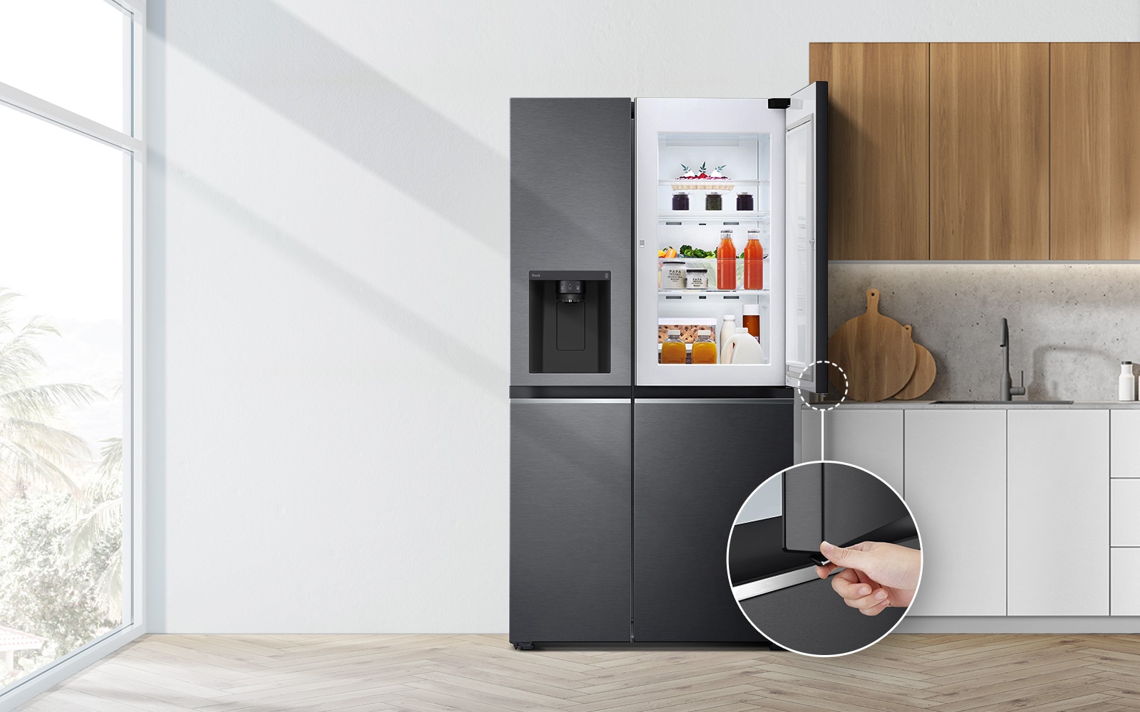 A front view of the refrigerator installed in a kitchen. The top right door is open and there is a circle and a line leading to a larger circle that shows a magnified view of the button on the bottom left corner of the open door which has a concealed opening button.