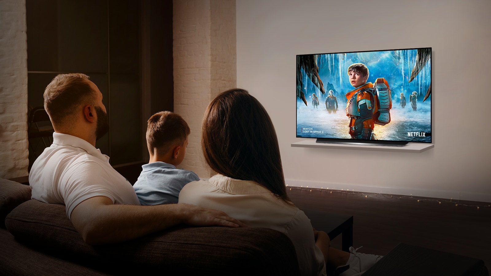 Couple sitting on a sofa in the living room watching a romantic movie on TV