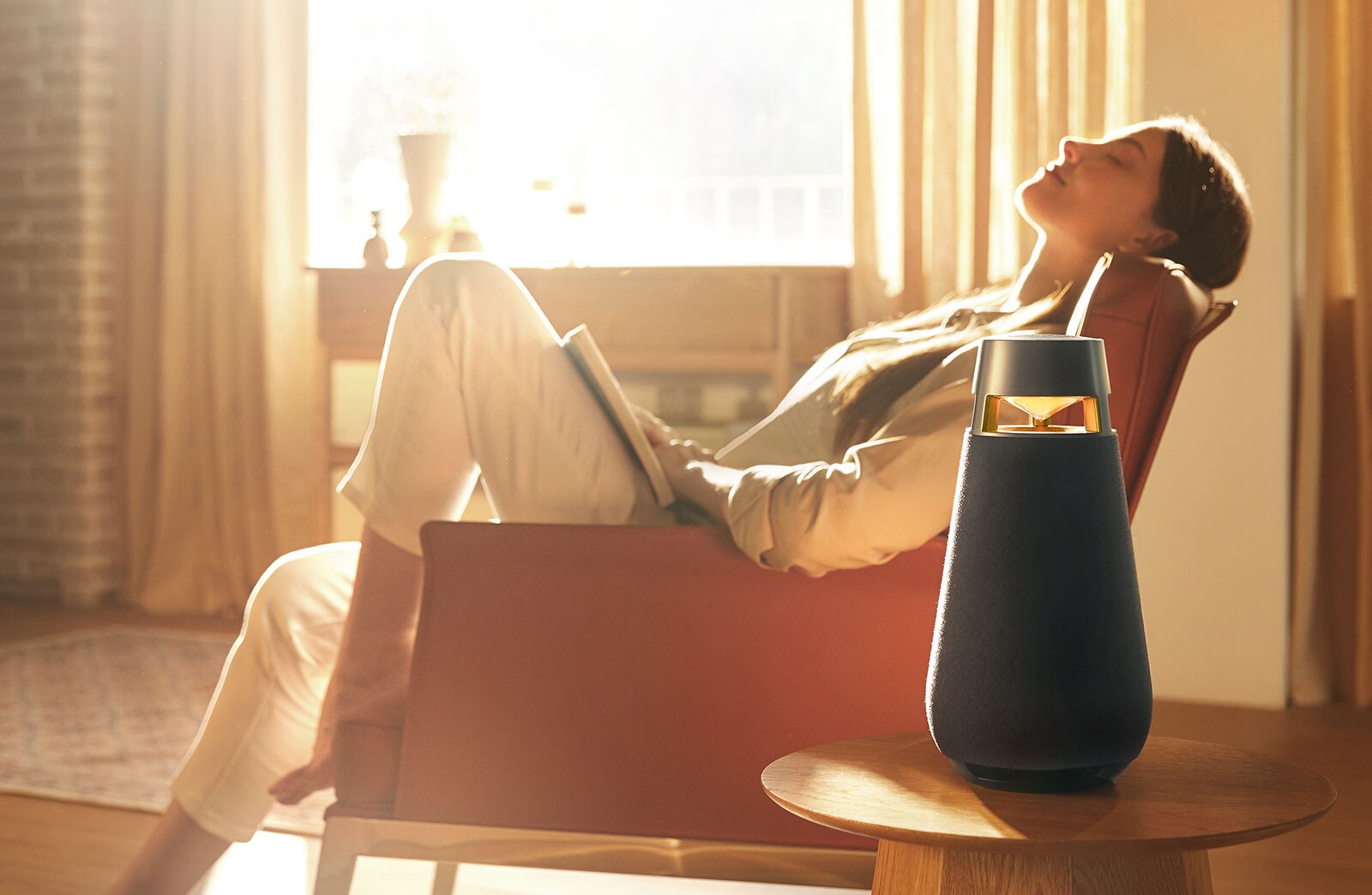 A woman is listening to music while sitting on a sofa.